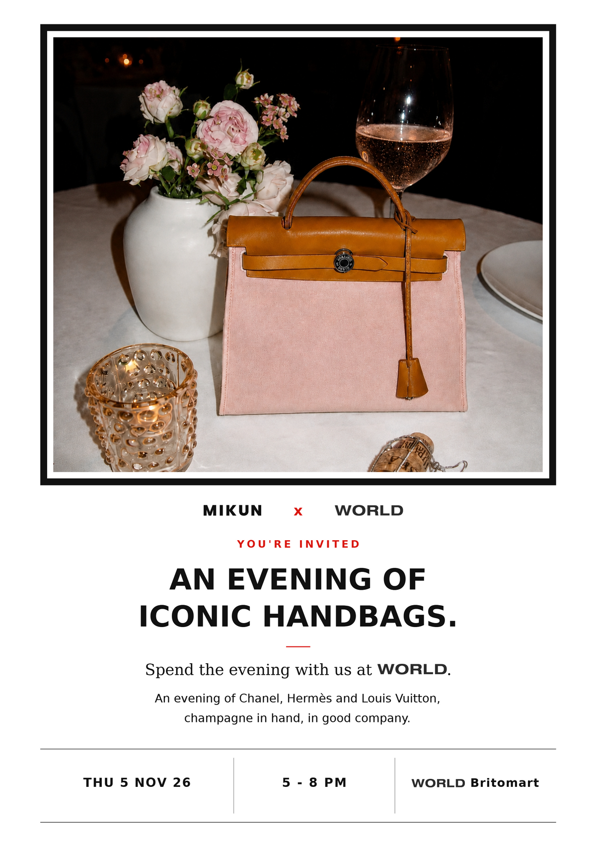 A pink Hermès Herbag on a candlelit table beside roses and a glass of rosé champagne